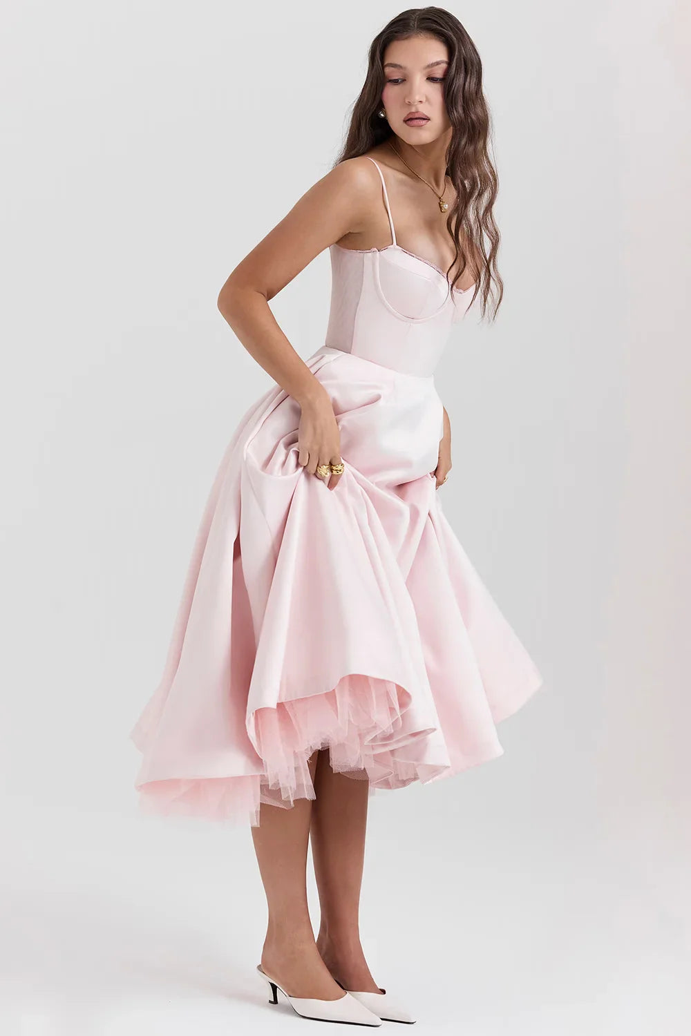 Model from the back wearing Kouvr Fashion's blush pink 1950s style fit and flare dress with a full tulle skirt