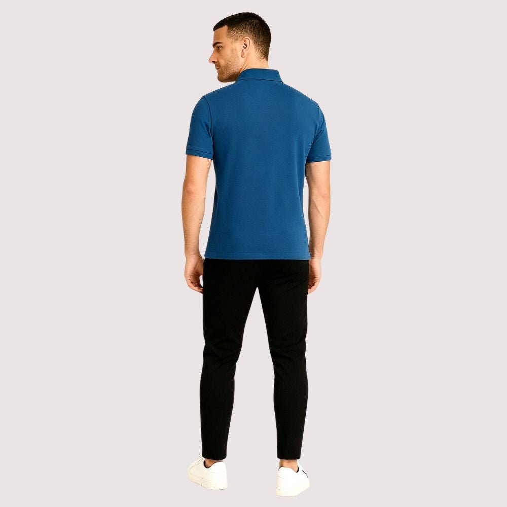 Model wearing the Kouvr Fashion Men's Slim Fit Piqué Polo in Azure Blue with black pants.