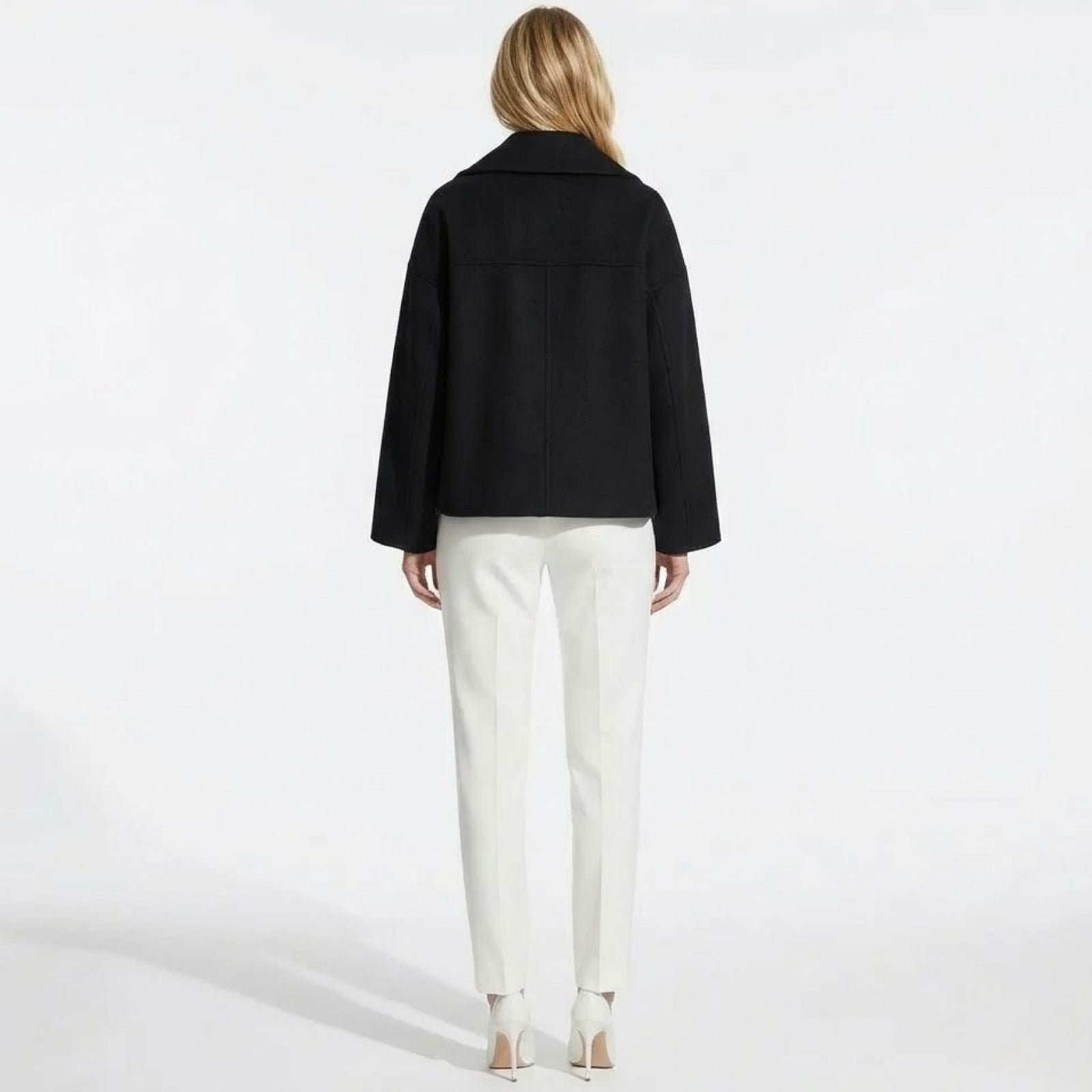 Back view of the Kouvr Fashion black cropped wool peacoat, displaying the central seam and shoulder structure.
 