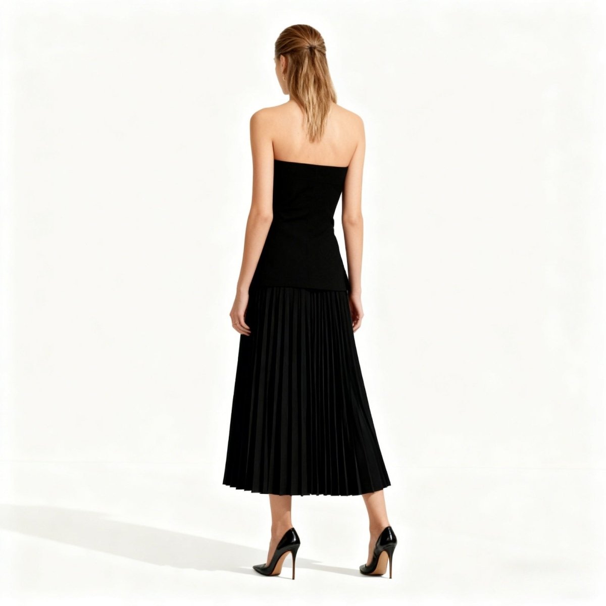 Woman wearing a black strapless dress on a white background