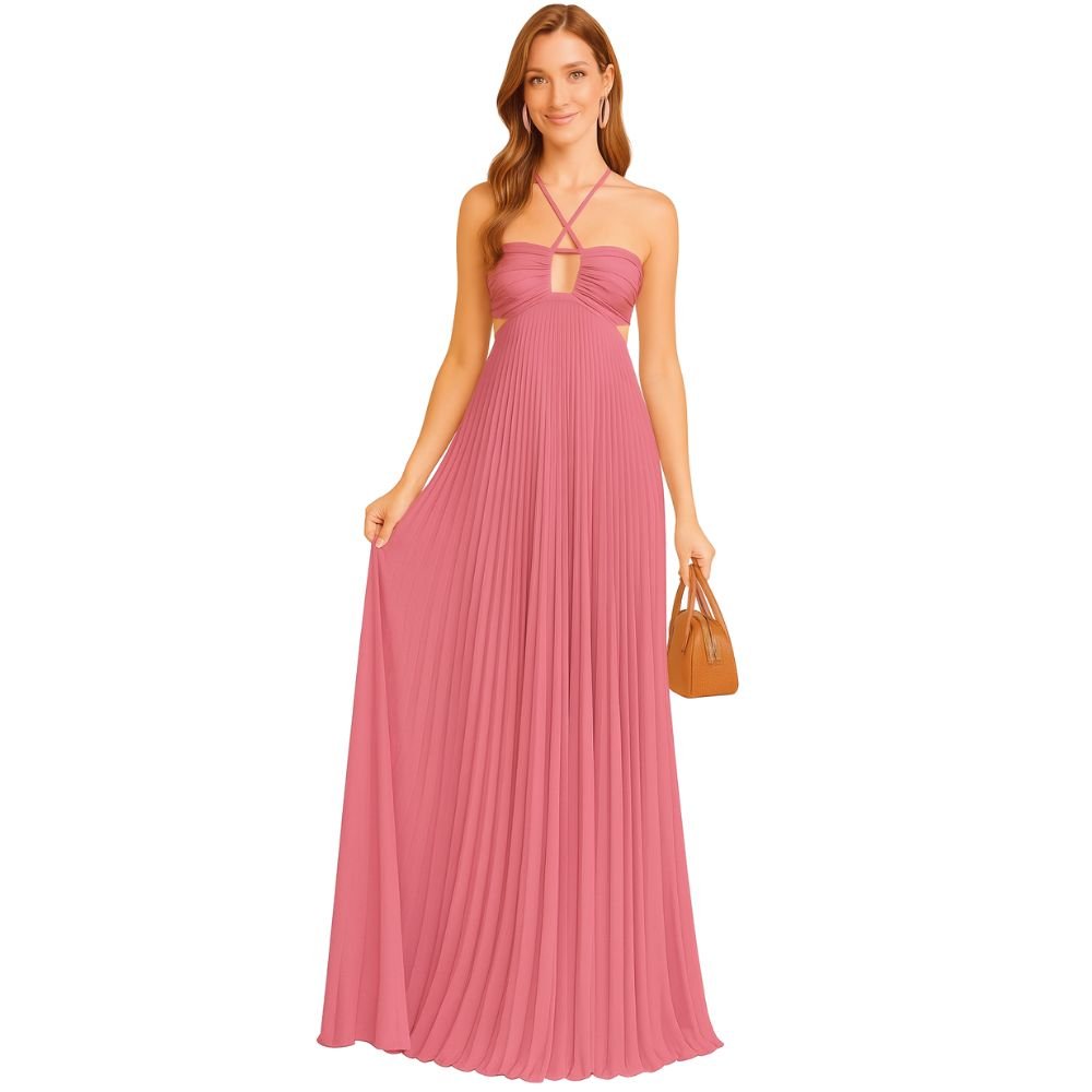 Model wearing the Kouvr Daphne Gown, a pink pleated halter maxi dress with waist cutouts, in a stone courtyard