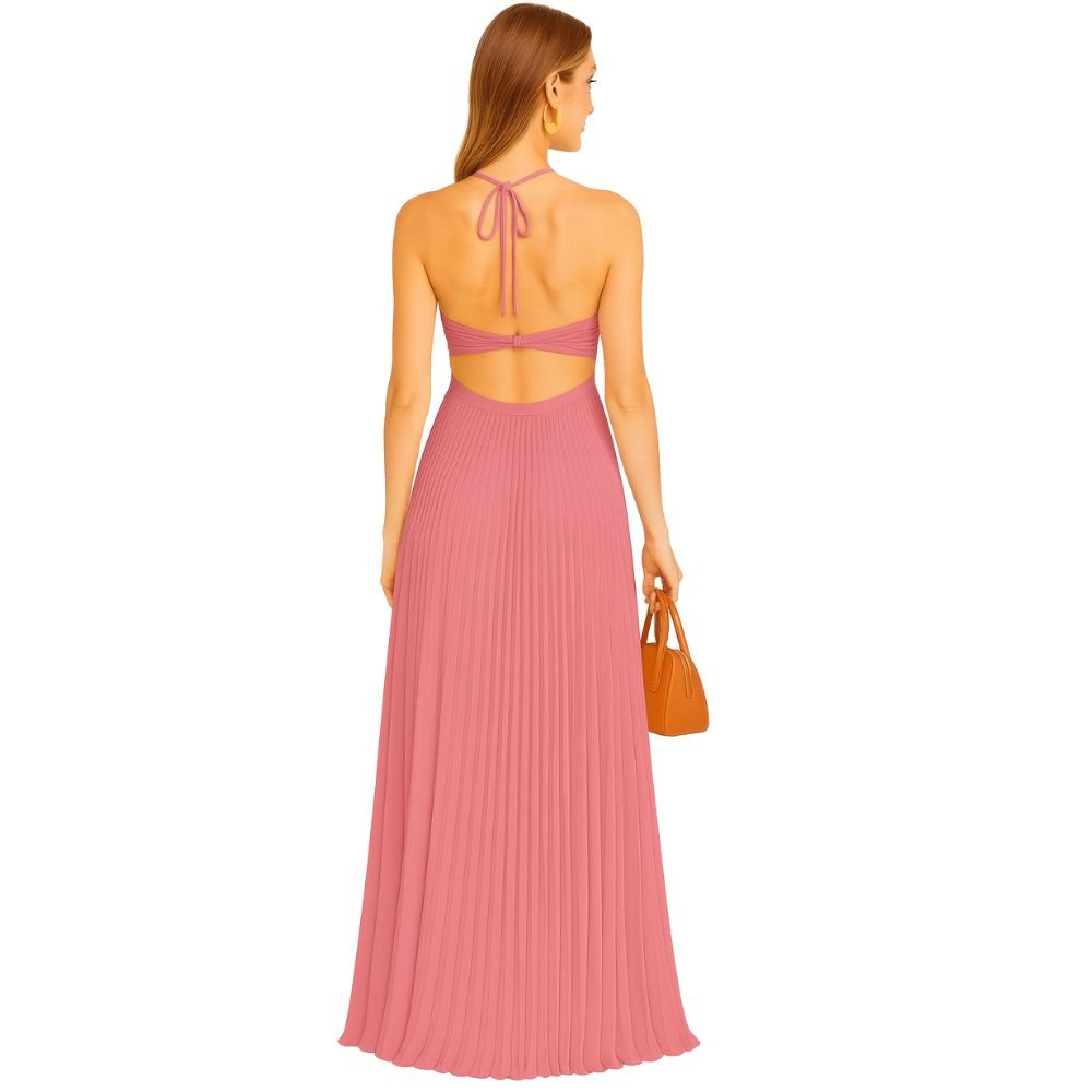 Model wearing the Kouvr Daphne Gown, a pink pleated halter maxi dress with waist cutouts, in a stone courtyard