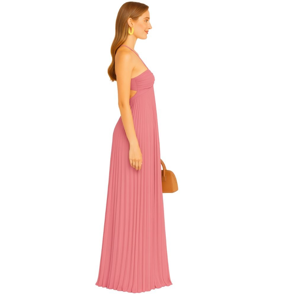 Model wearing the Kouvr Daphne Gown, a pink pleated halter maxi dress with waist cutouts, in a stone courtyard