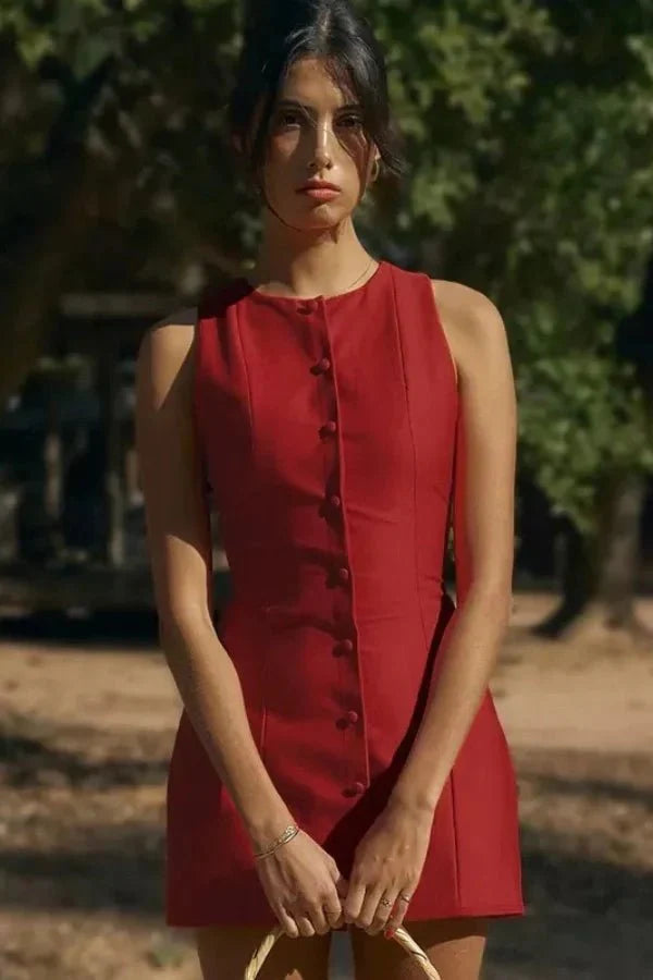 Model wearing the Kouvr Cosette sleeveless red mini dress in a rustic setting