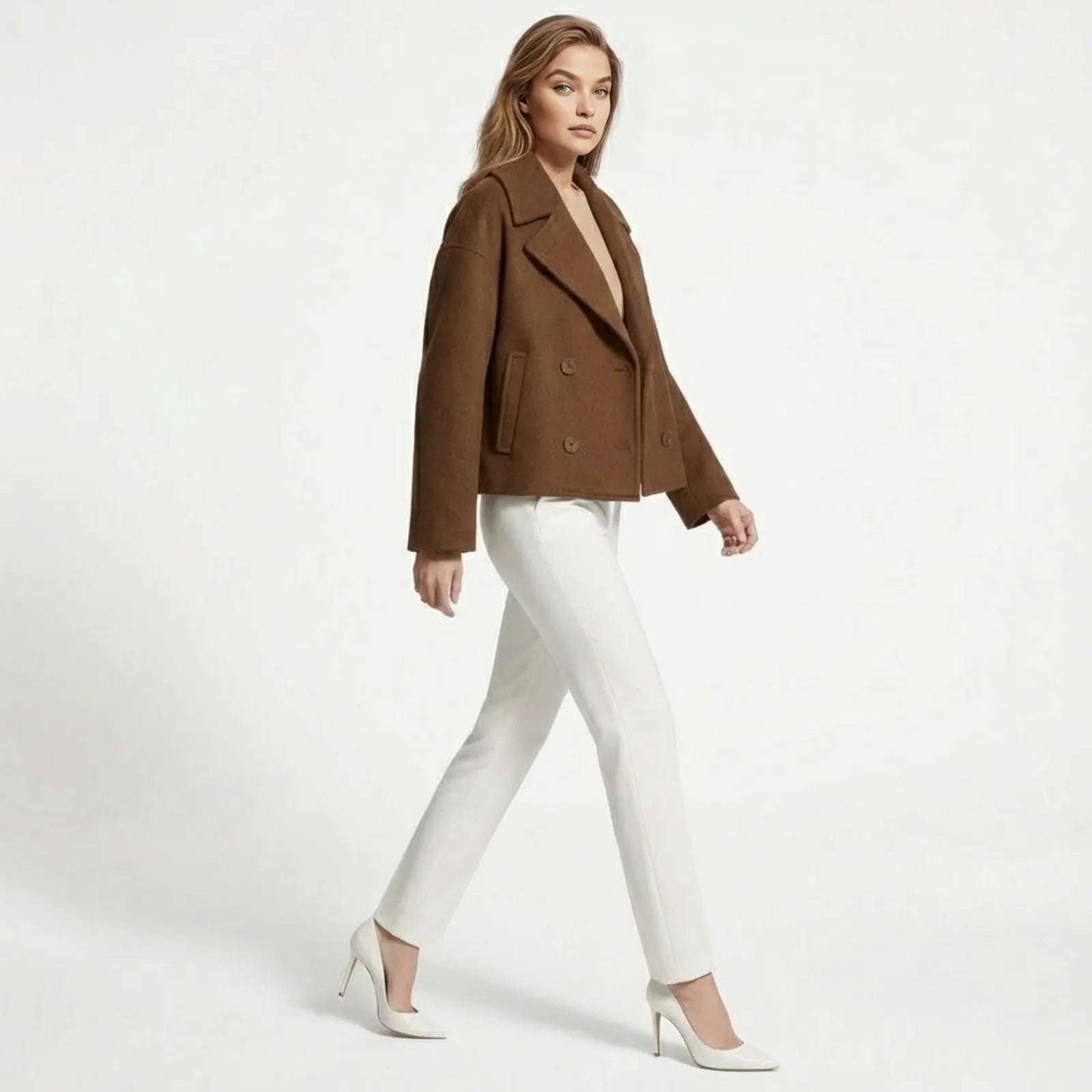 Side profile of a model walking in the Kouvr Fashion cognac brown cropped wool jacket, showing its silhouette and movement.

