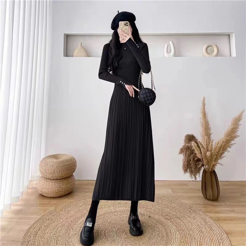 Full-length view of a woman in the black Dannah pleated knit dress by Kouvr Fashion, paired with a black beret and chunky loafers for a chic look.