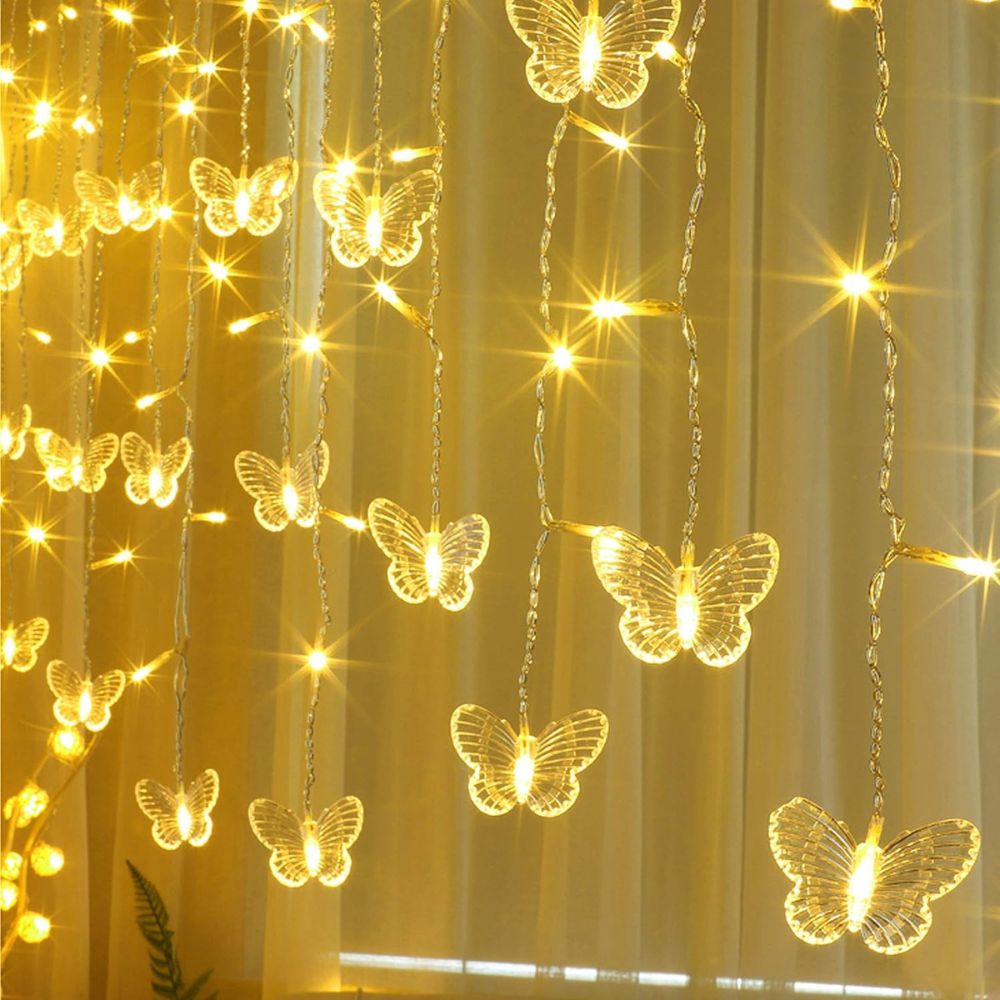 Kouvr Fashion's Fairy Flutter Lights creating a magical, romantic glow over a headboard in a luxury bedroom