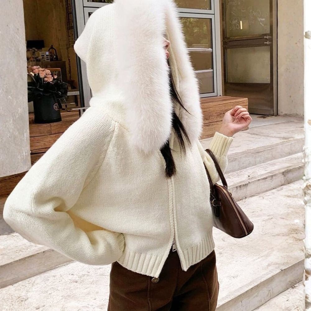 Woman wearing the Kouvr ivory knit hoodie with plush faux fur trim, styled with matching wide-leg pants