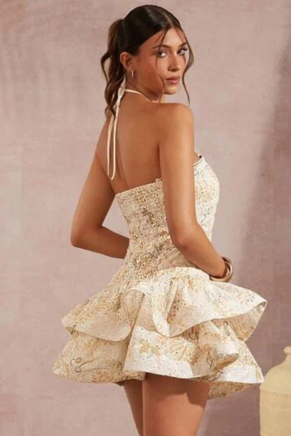 Model wearing Kouvr Fashion Faye beige embroidered halter mini dress with tiered ruffles