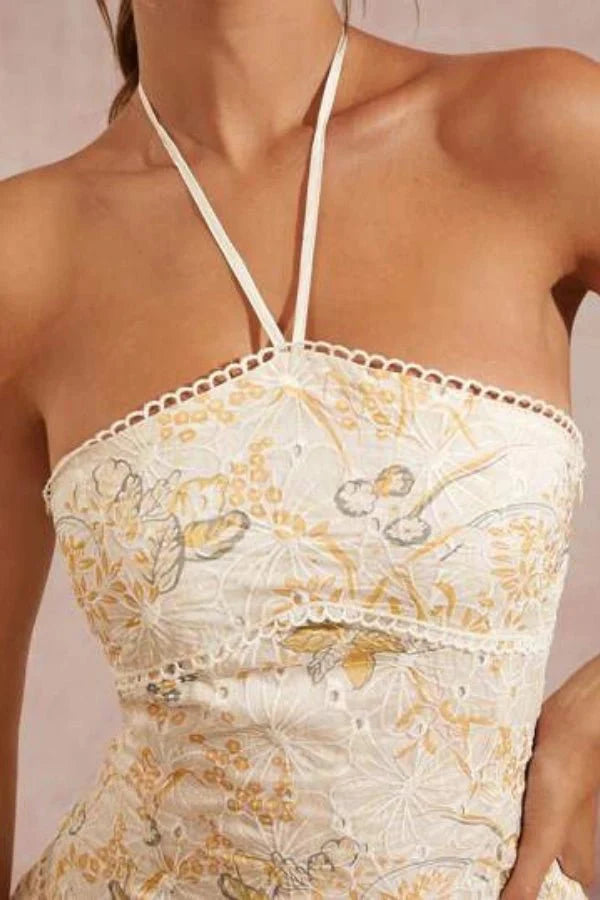 Model wearing Kouvr Fashion Faye beige embroidered halter mini dress with tiered ruffles