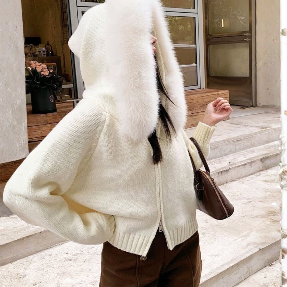 Person wearing a ivory sweater with fur trim outdoors