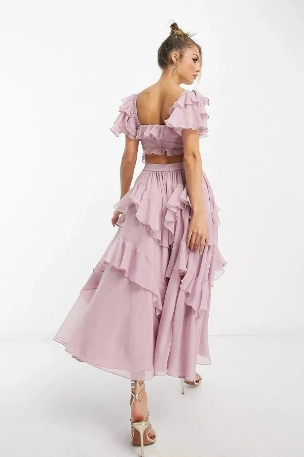 Model wearing Kouvr Fashion Freyna dusty lilac two-piece ruffle dress with corset top and tiered midi skirt