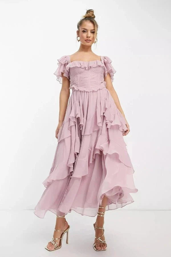Model wearing Kouvr Fashion Freyna dusty lilac two-piece ruffle dress with corset top and tiered midi skirt