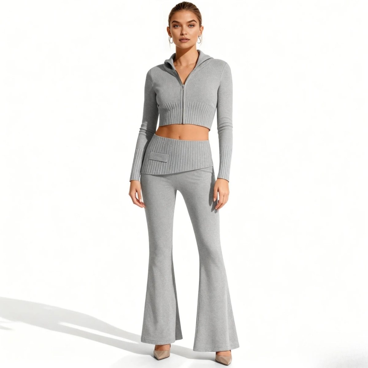 A model wearing the Kouvr Fashion two-piece grey knit lounge set, facing forward. The set includes a cropped zip-up hoodie and high-waisted flared pants.
