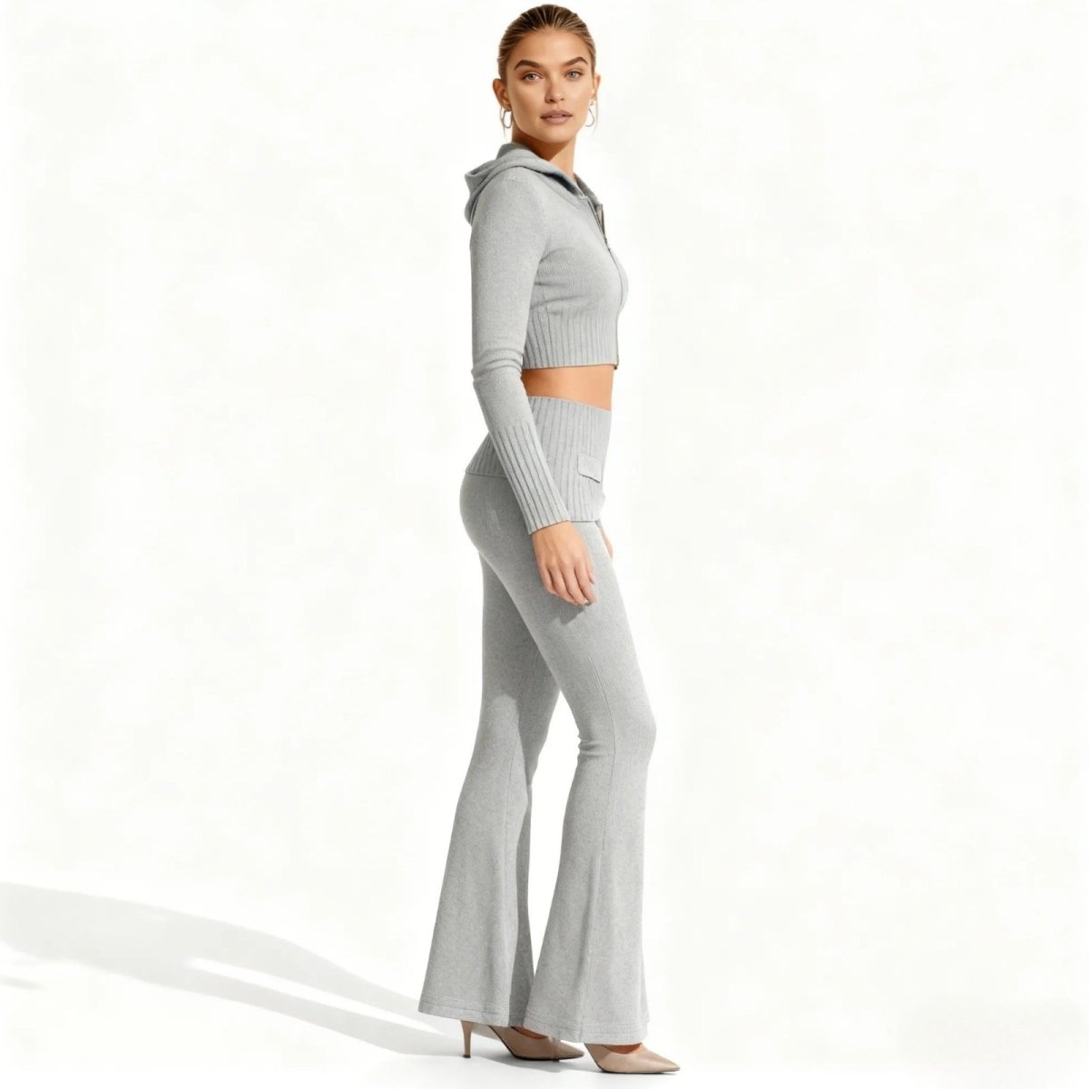 A side view of a model in the grey ribbed knit co-ord set from Kouvr Fashion, showcasing the silhouette of the flared pants and cropped hoodie.