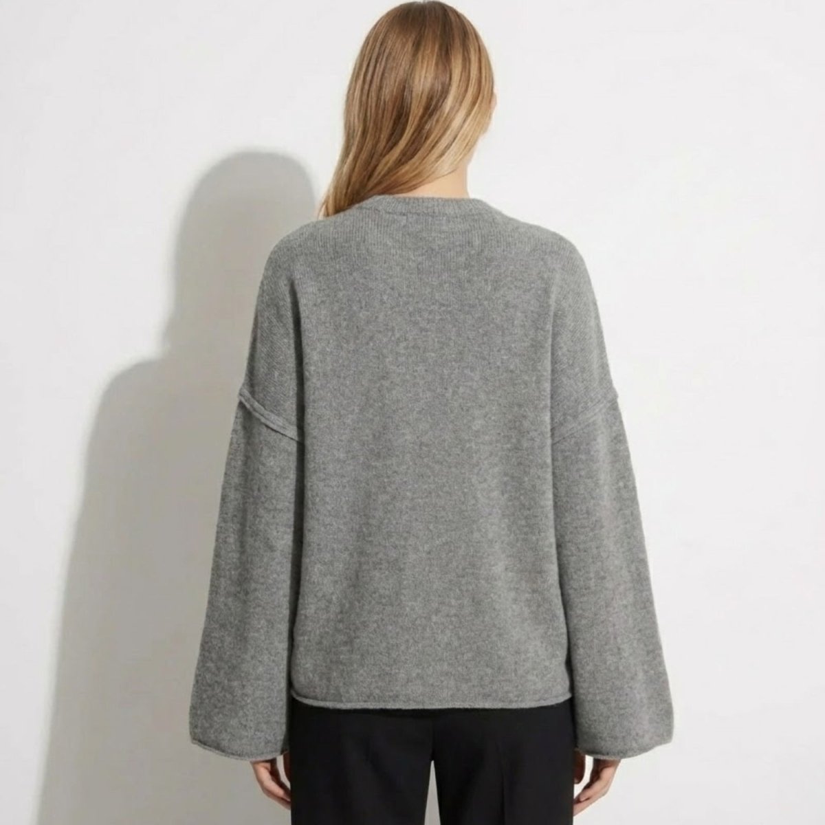 Back view of the Kouvr Fashion oversized grey knit sweater, showing the minimalist silhouette and drape.