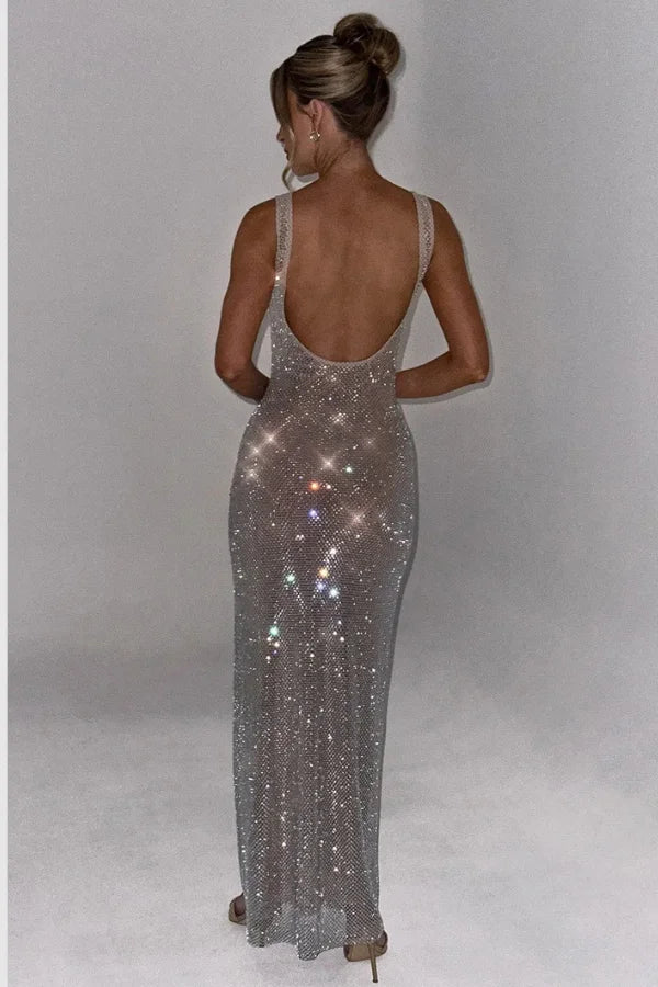 Model wearing the Kouvr Fashion Isabeu Gown, a silver floor-length rhinestone crystal mesh dress with a square neckline