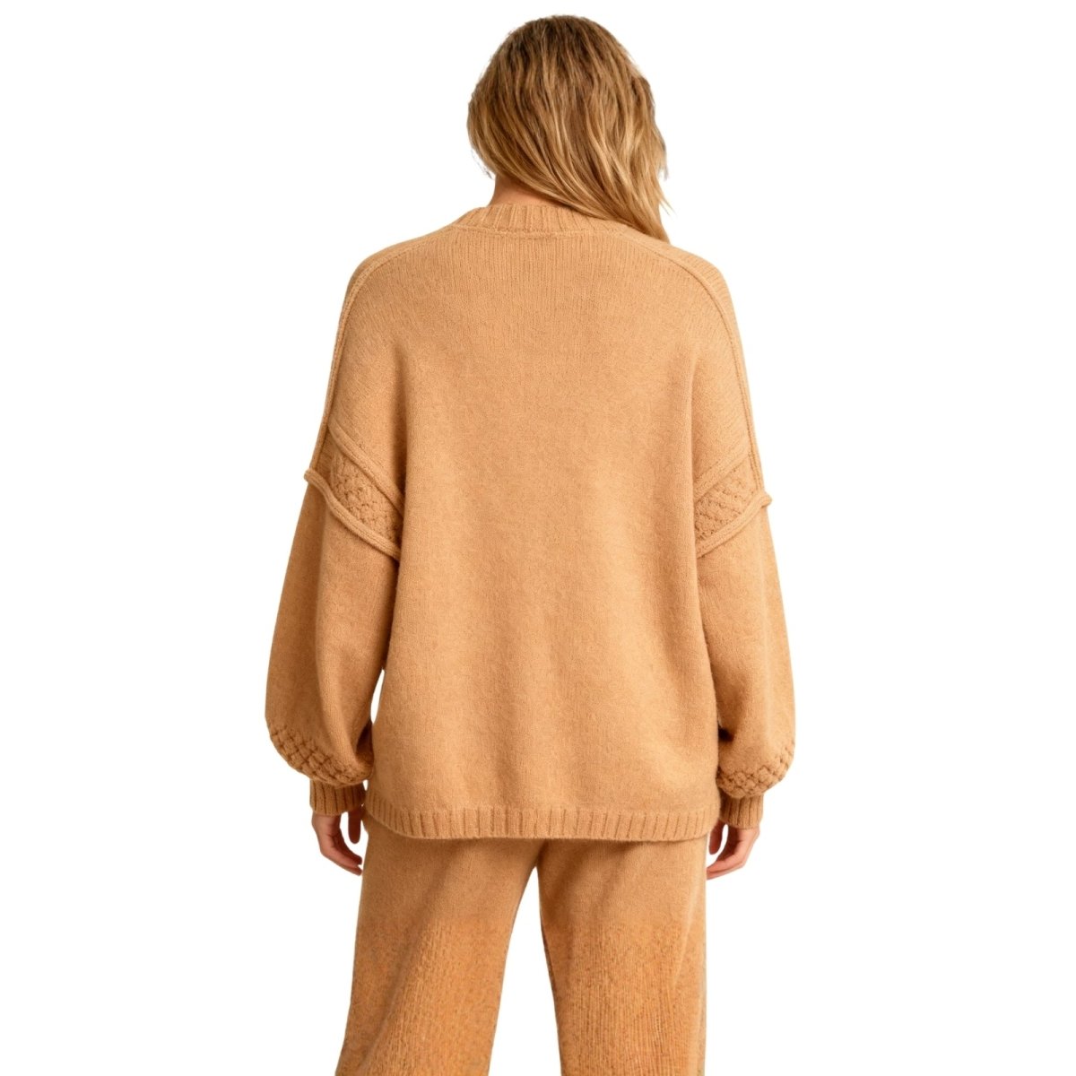 Person wearing a Khaki Kouvr sweater and pants set on a white background