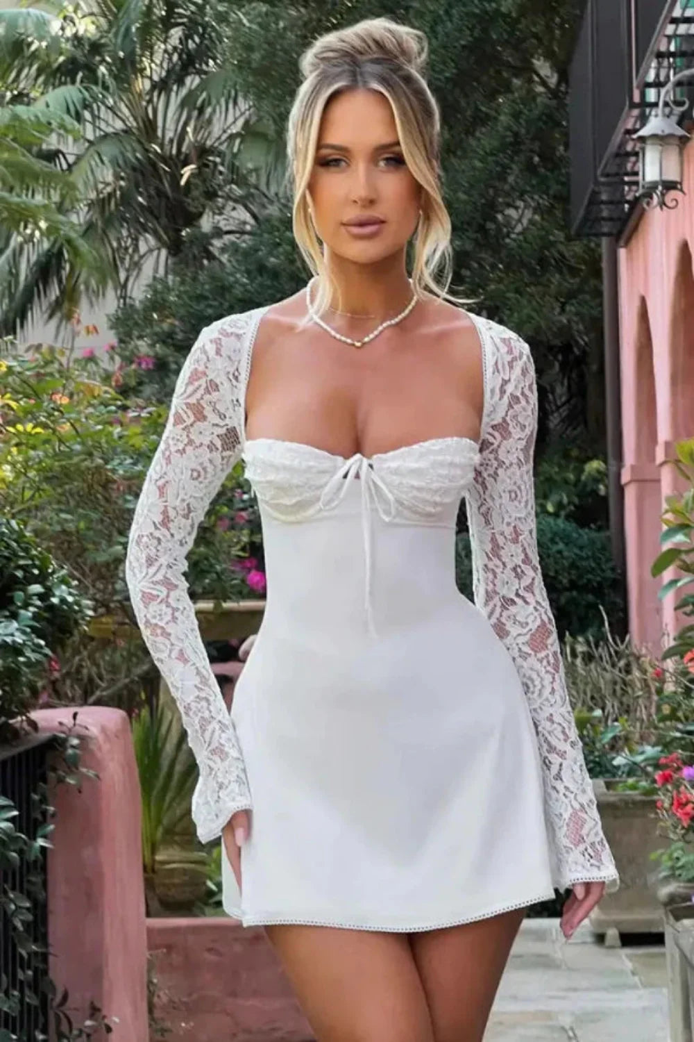 Model from behind wearing the Kouvr Fashion Louise white lace corset mini dress showing the adjustable back lacing