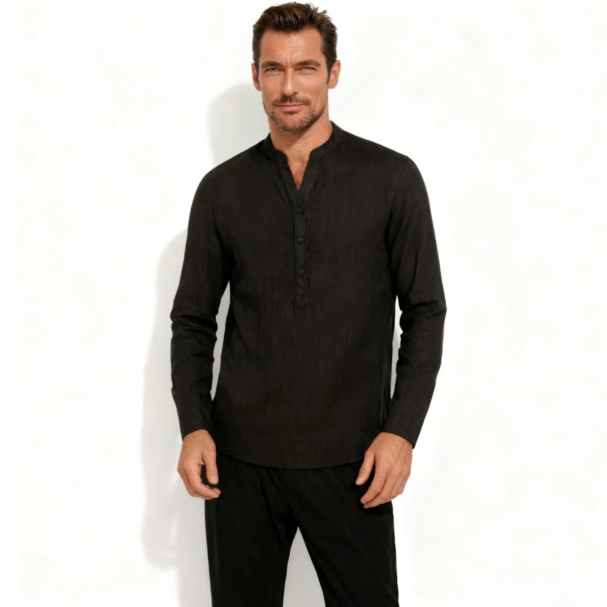 Male model wearing the Kouvr Fashion black long sleeve collarless linen shirt, facing forward against a white background.

