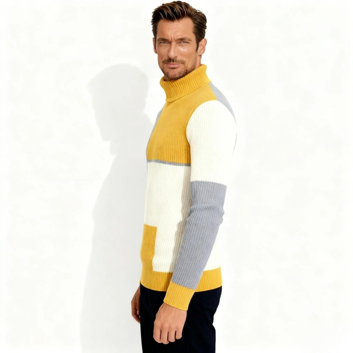 Side profile of a male model in a slim fit ribbed knit turtleneck with yellow, white, and cream color blocks showing the sleeve design.
