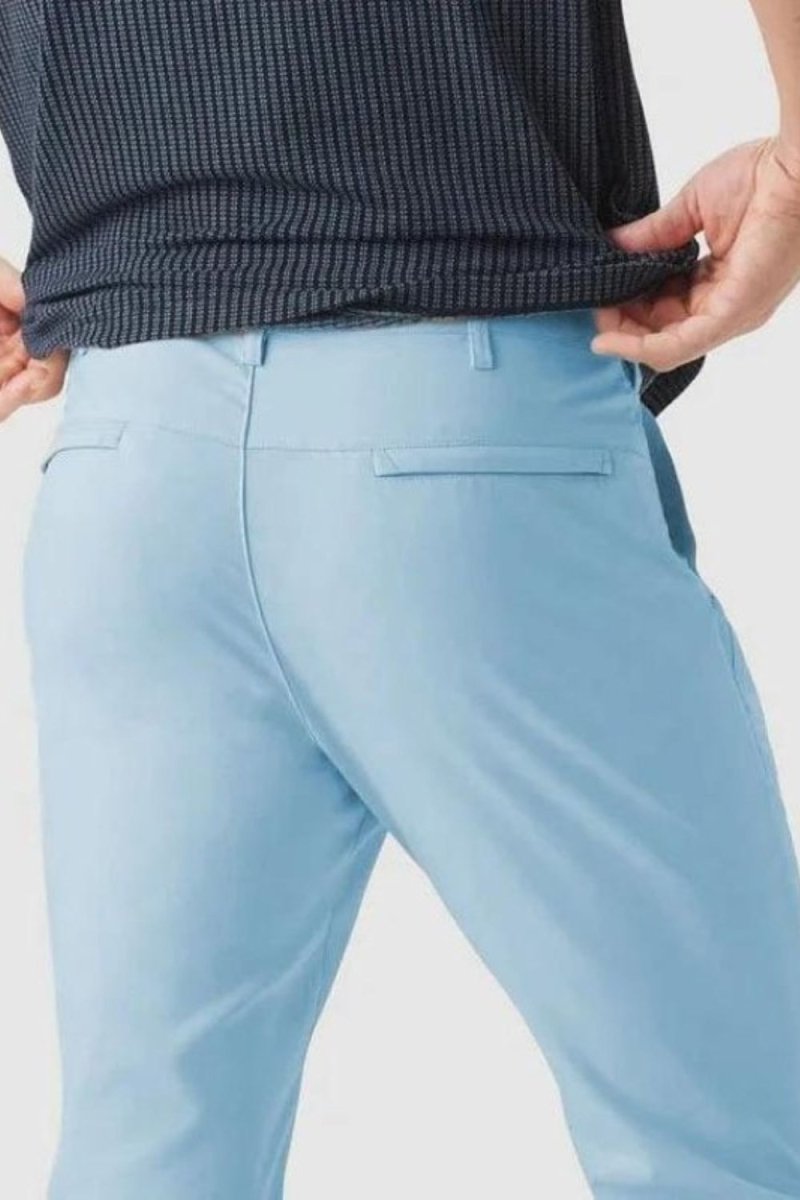 Man wearing Kouvr modern slim fit performance trousers in blue, showing clean lines and back pocket detail