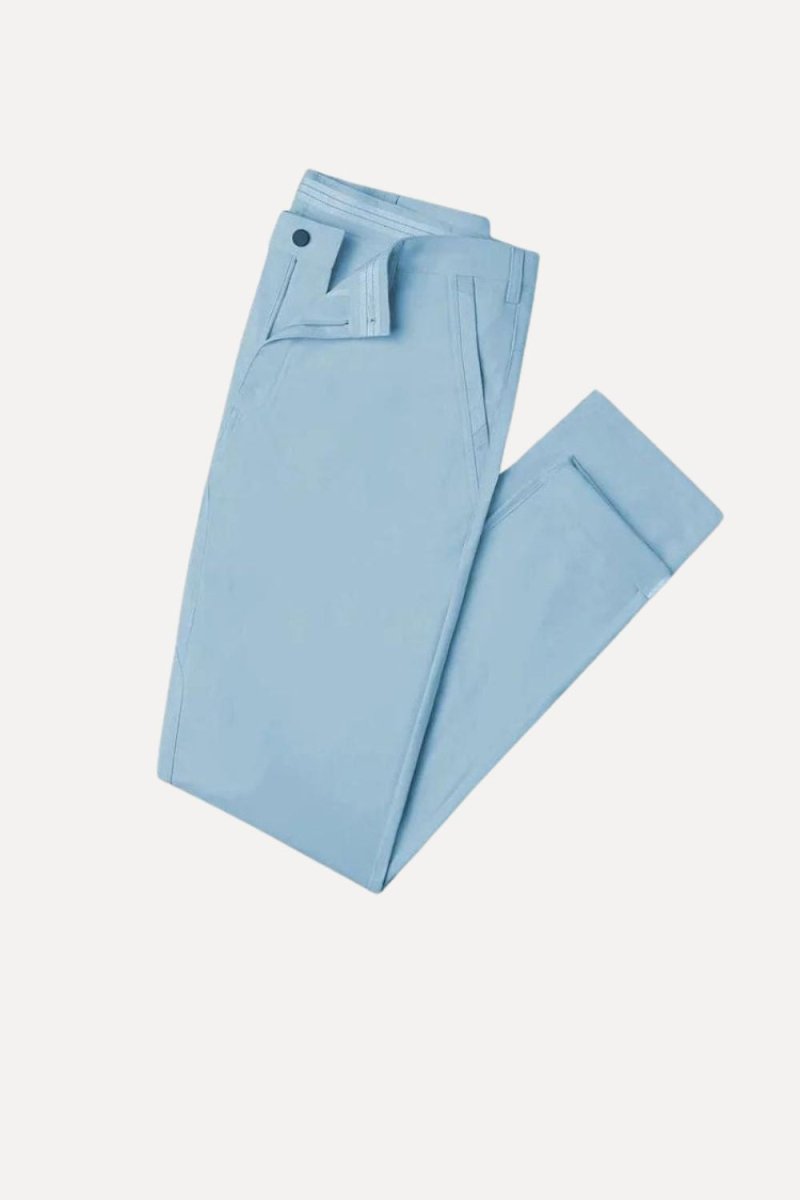 Man wearing Kouvr modern slim fit performance trousers in blue, showing clean lines and back pocket detail