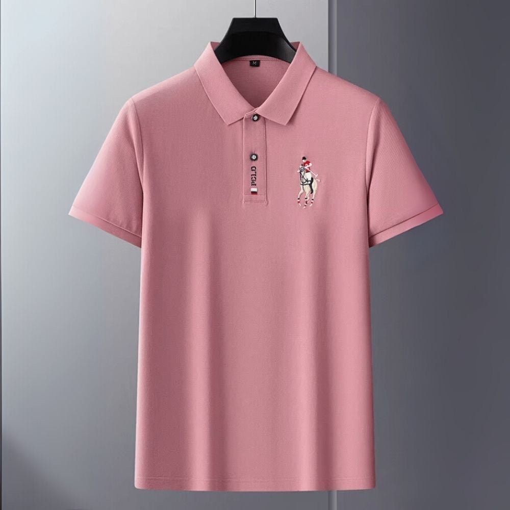 Man wearing the Kouvr slim fit Rose Quartz pink polo shirt with black trousers against a white background.