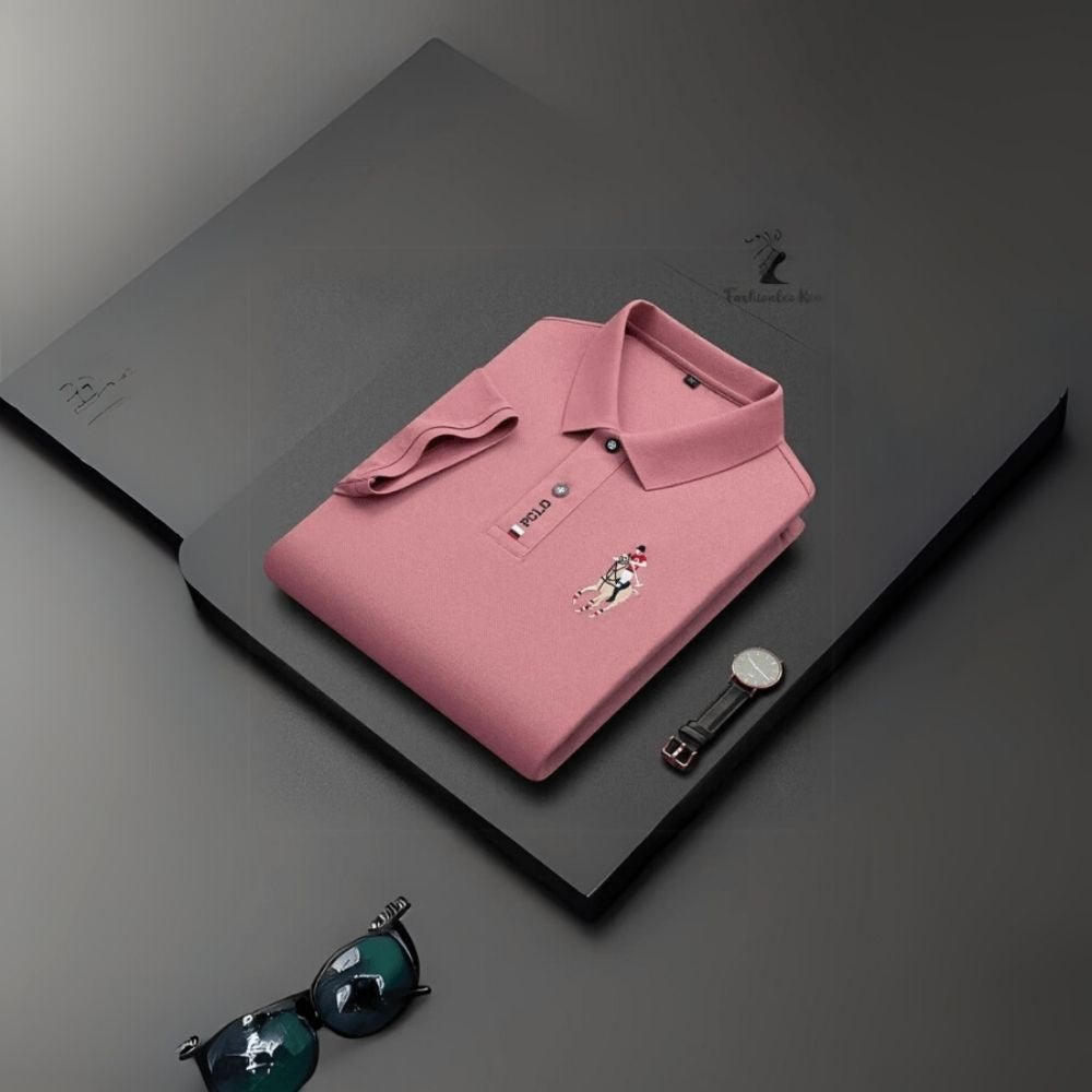 Man wearing the Kouvr slim fit Rose Quartz pink polo shirt with black trousers against a white background.