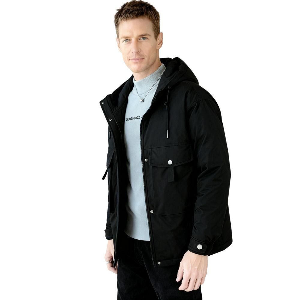 Man wearing a black kouvr jacket over a light gray shirt on a white background