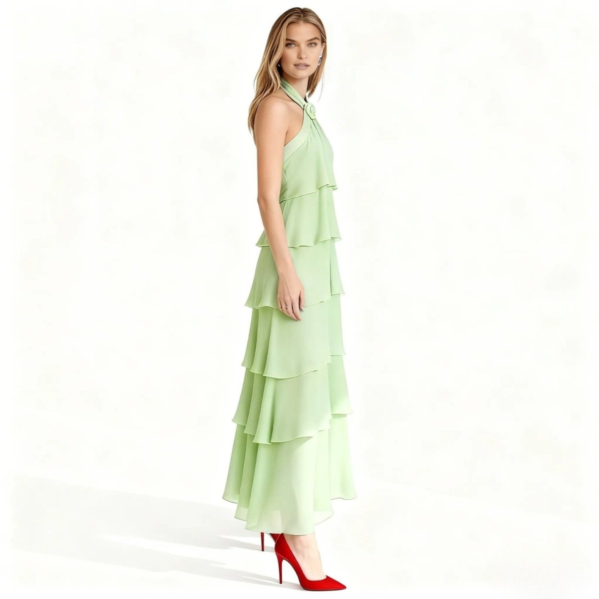 Woman wearing a light green Kouvr tiered dress on a white background
