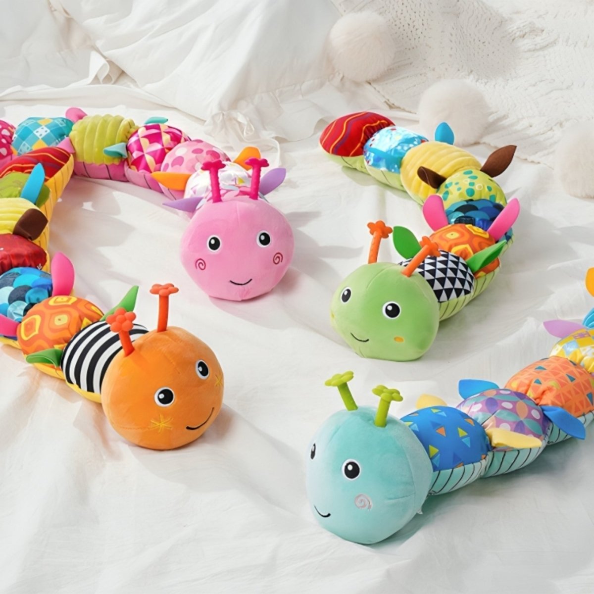 Colorful caterpillar-shaped plush toys on a white background