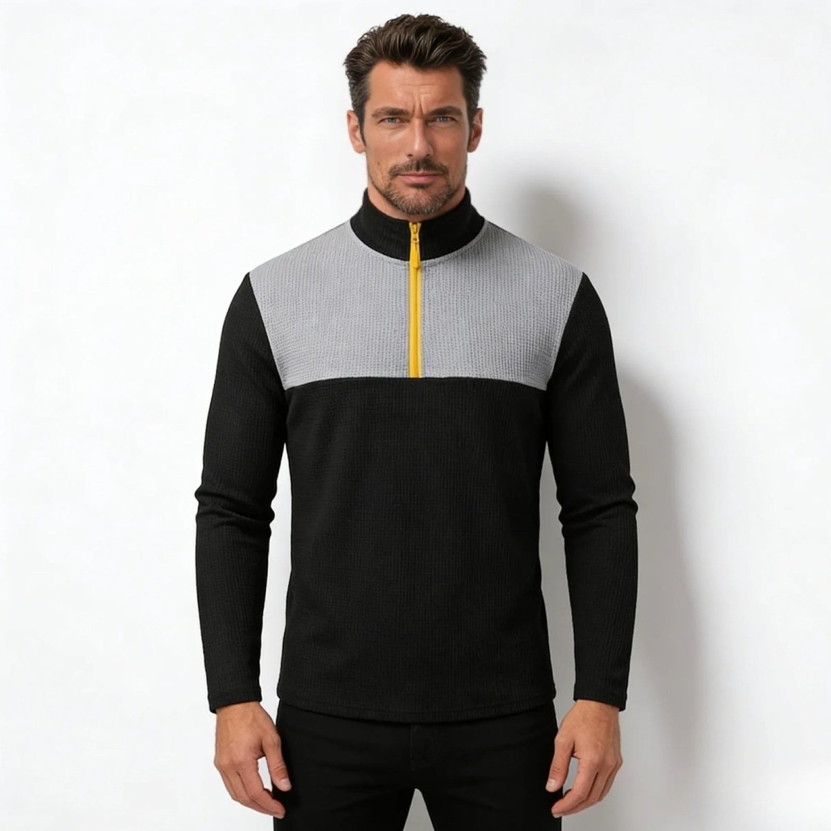 Model wearing the Kouvr Fashion Ozzy men's quarter-zip sweater in black and grey, showcasing the waffle knit texture and contrasting yellow zipper.