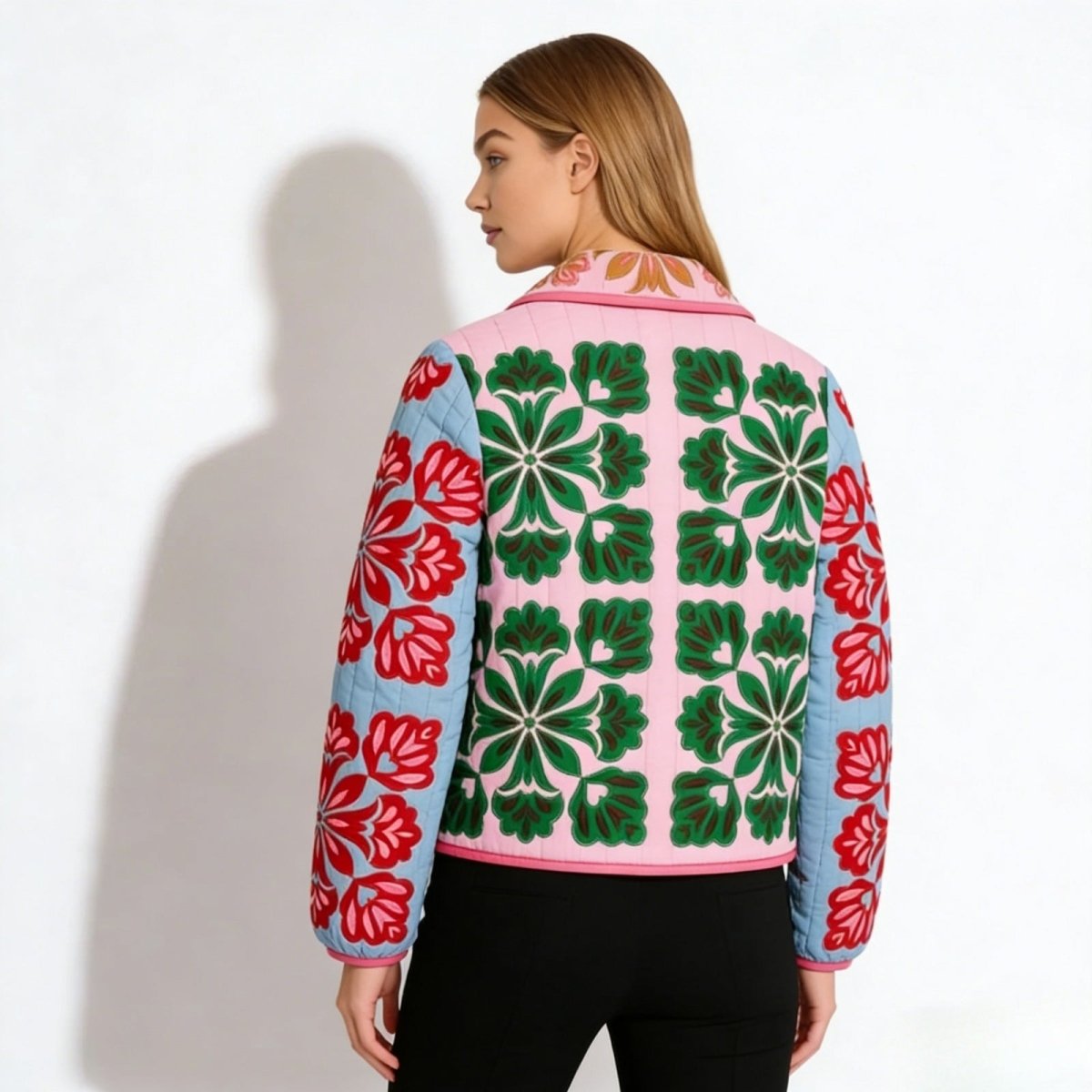 Back view of the Kouvr Fashion quilted jacket, highlighting the symmetrical green floral embroidery pattern on the pink back panel.