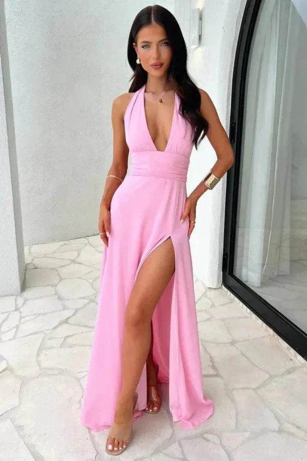 Model wearing the Kouvr Fashion pink backless halter neck maxi dress with a thigh-high slit, front view.' and 'Rear view of the Kouvr Fashion pink maxi dress showing the open back and tie details