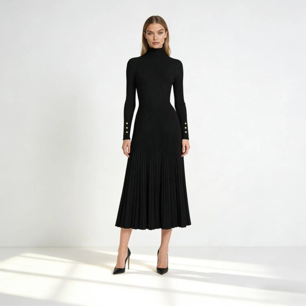 Model wearing the Kouvr Fashion black pleated knit turtleneck midi dress, front view, showcasing the ribbed bodice and A-line skirt.