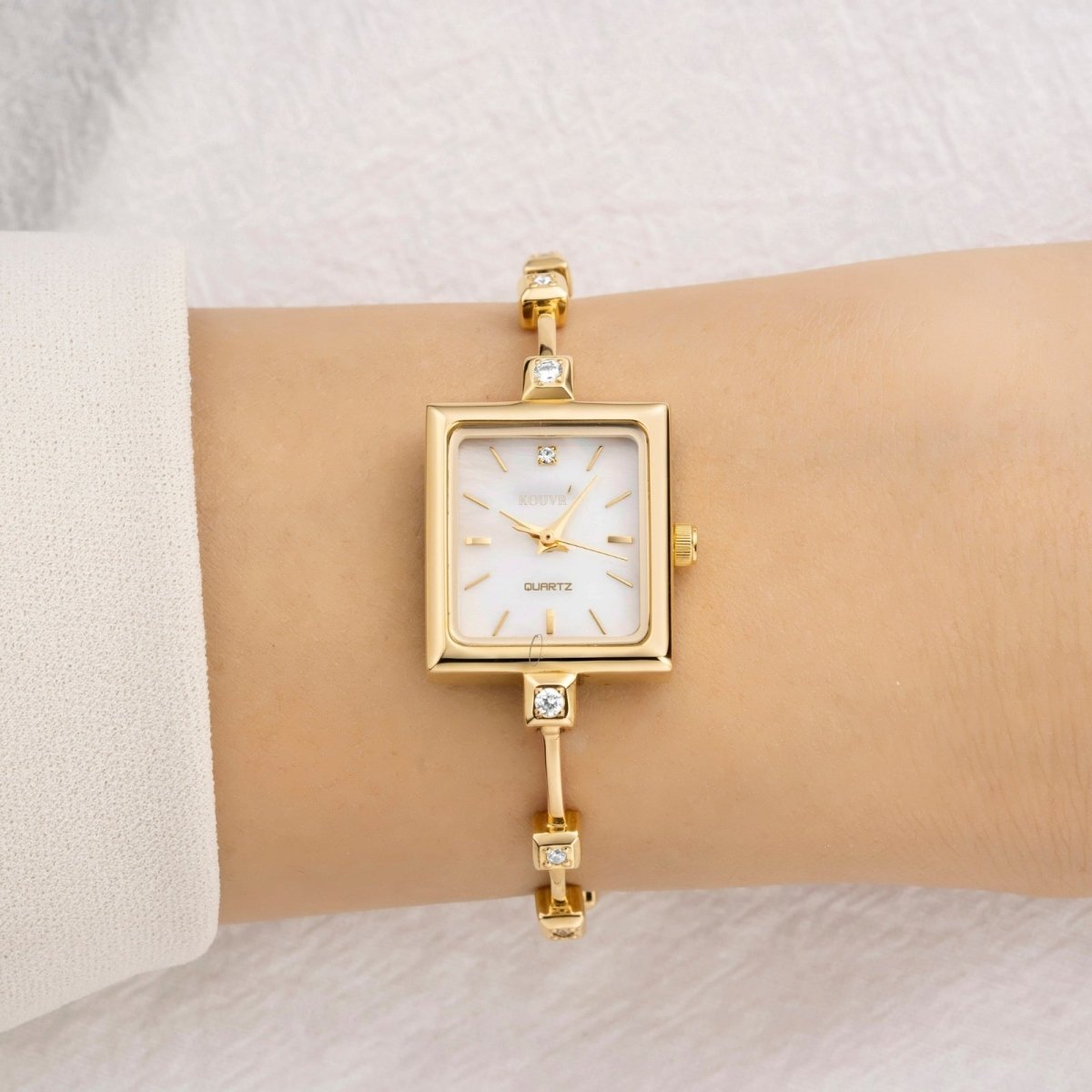 Gold kouvr bracelet with a clasp on a white background