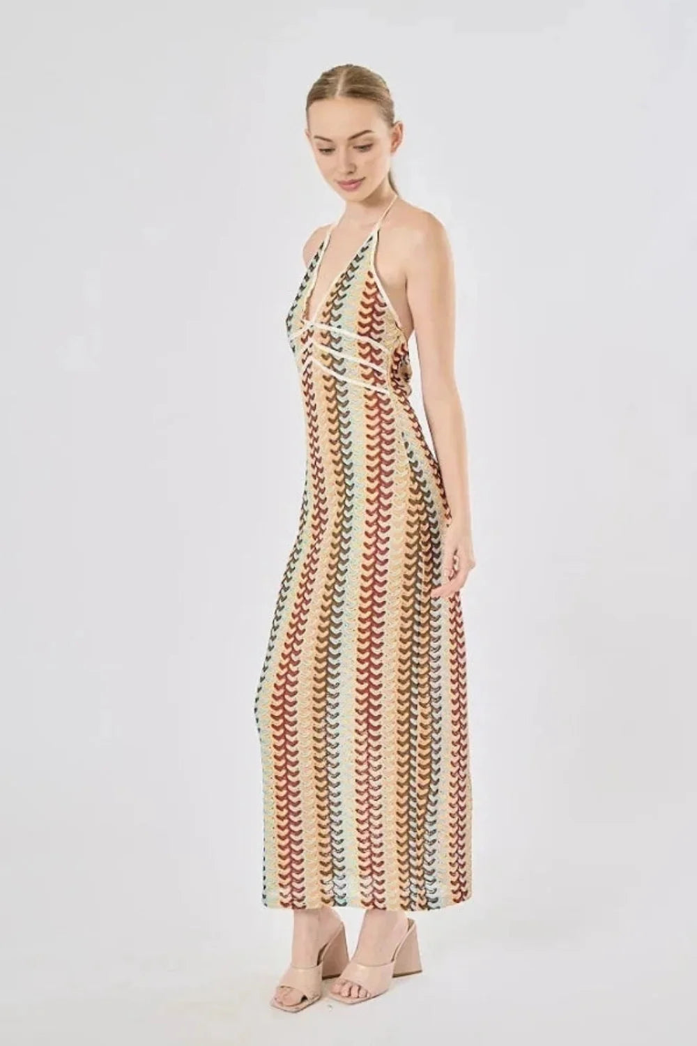 Model viewed from the back wearing the Kouvr Fashion 70s-inspired retro wave print halter maxi dress, showcasing the open-back design