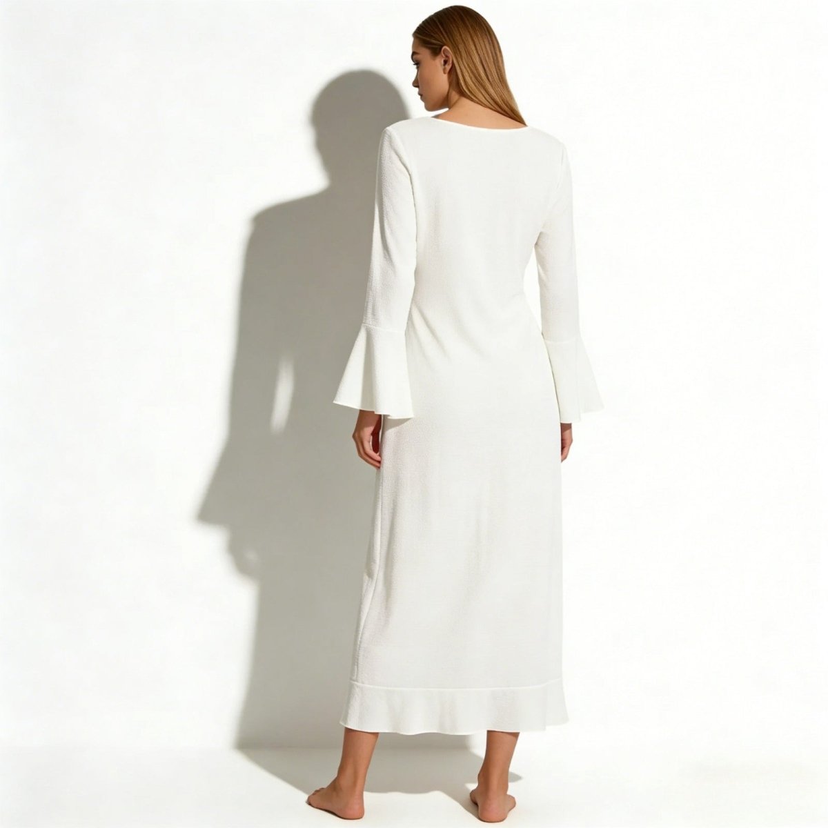 Back view of a woman wearing the Roseta white bell sleeve maxi cover up, highlighting the clean lines and sleeve shape.