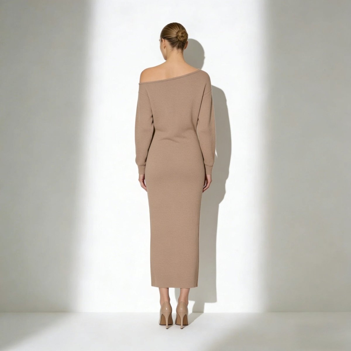 Model seen from the back wearing the Kouvr Fashion Selena asymmetrical knit midi dress in camel.