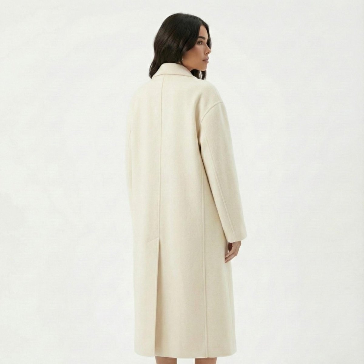 Back view of a Madison Beer in the Kouvr Fashion Maddie ivory wool coat, showing the central seam detail and rear vent.