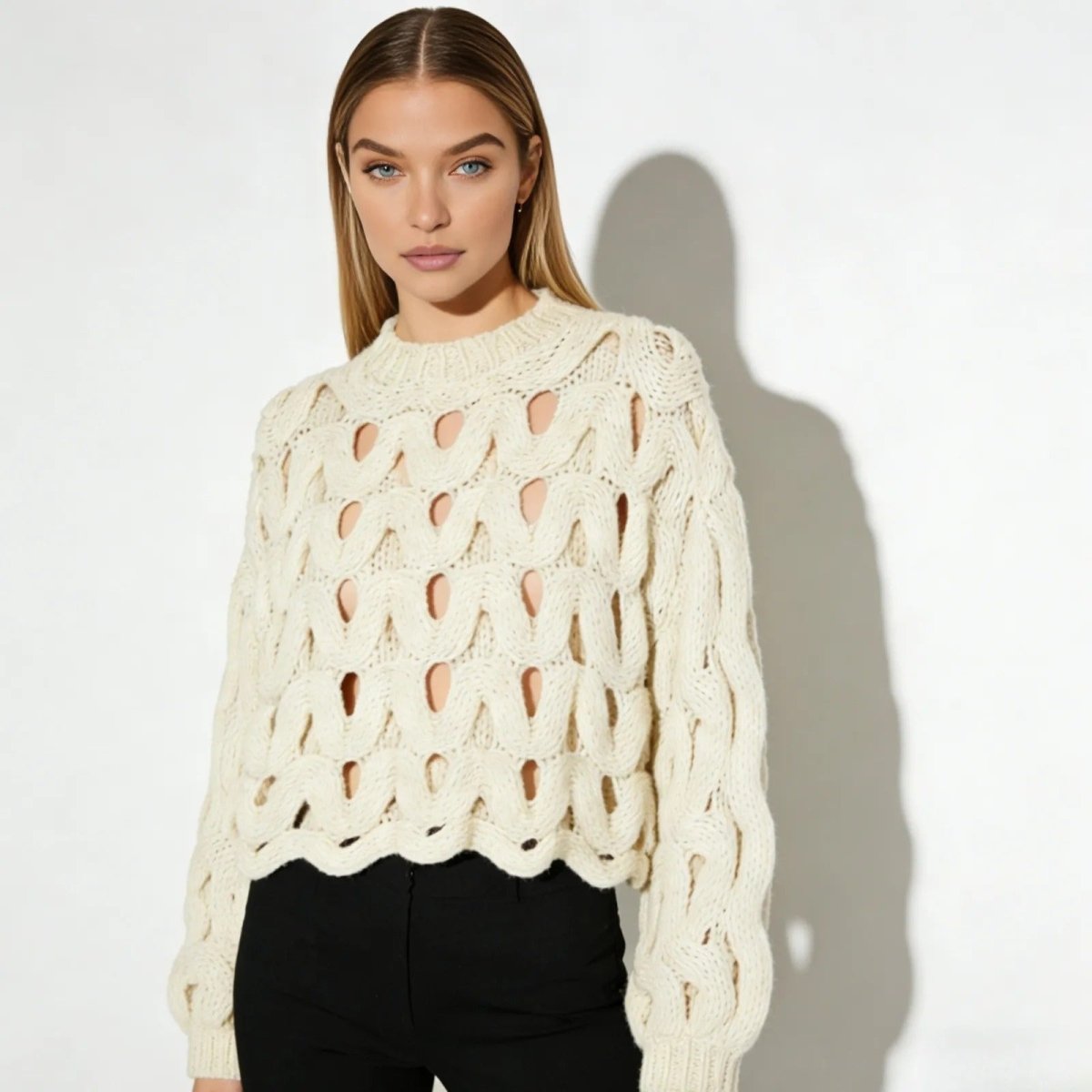 Model wearing the Kouvr Fashion Vanice open-knit sweater in ivory, styled with black high-waisted trousers.