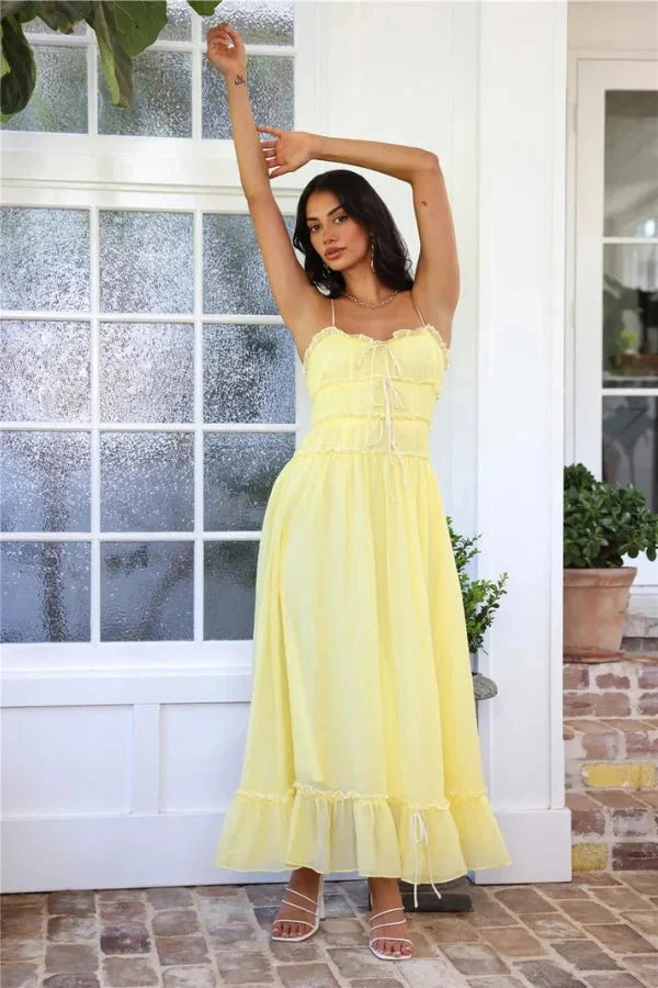 Model wearing the Kouvr Fashion Yoona Yellow Ruffle Midi Dress in a sunlit room