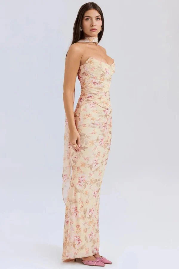 Side profile view of model wearing Kouvr Hailey yellow floral strapless maxi dress, showing drape and fit.