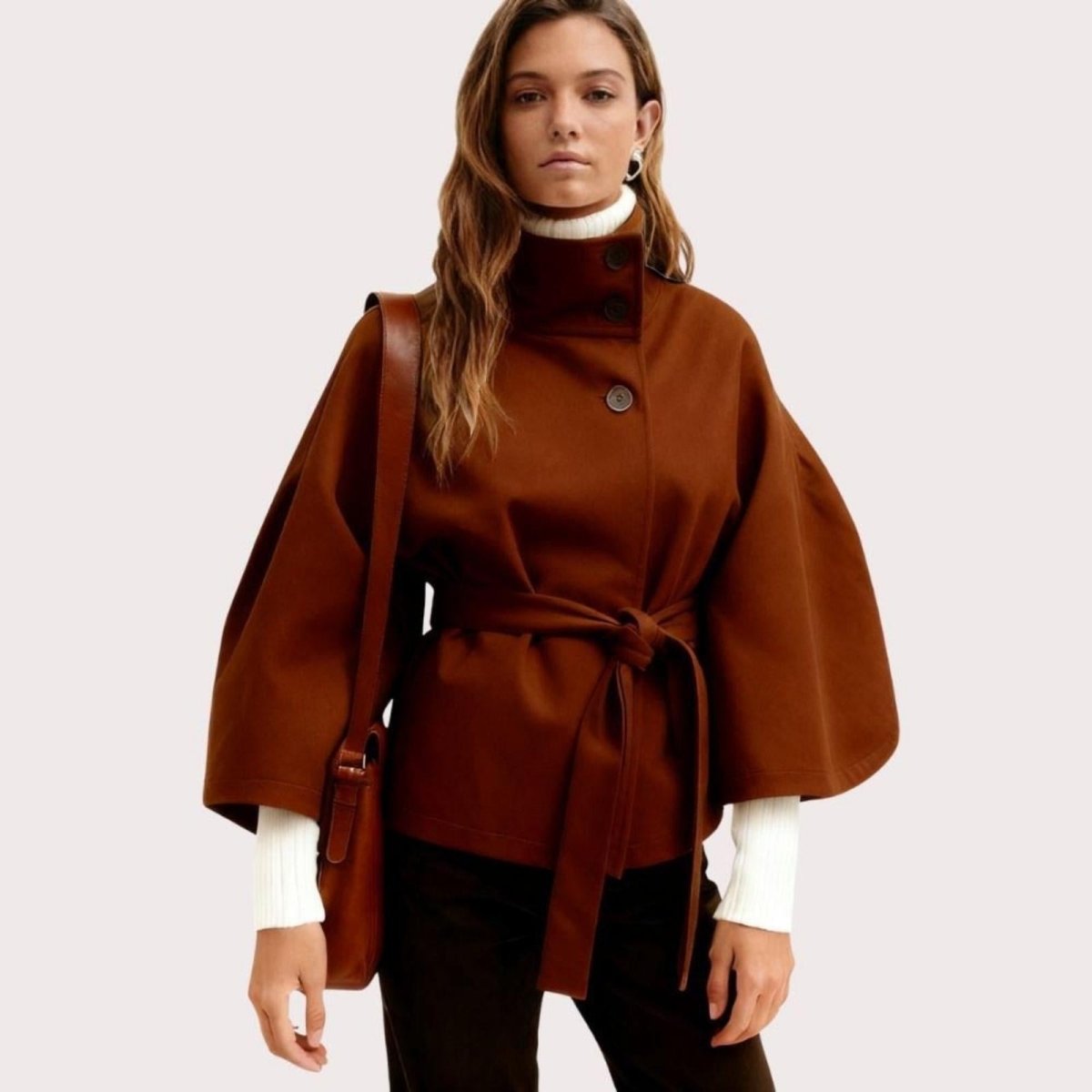 Model from the back wearing the Kouvr Jaye Belted Cape Jacket in Brown, showcasing the wide sleeves and tie-waist detail