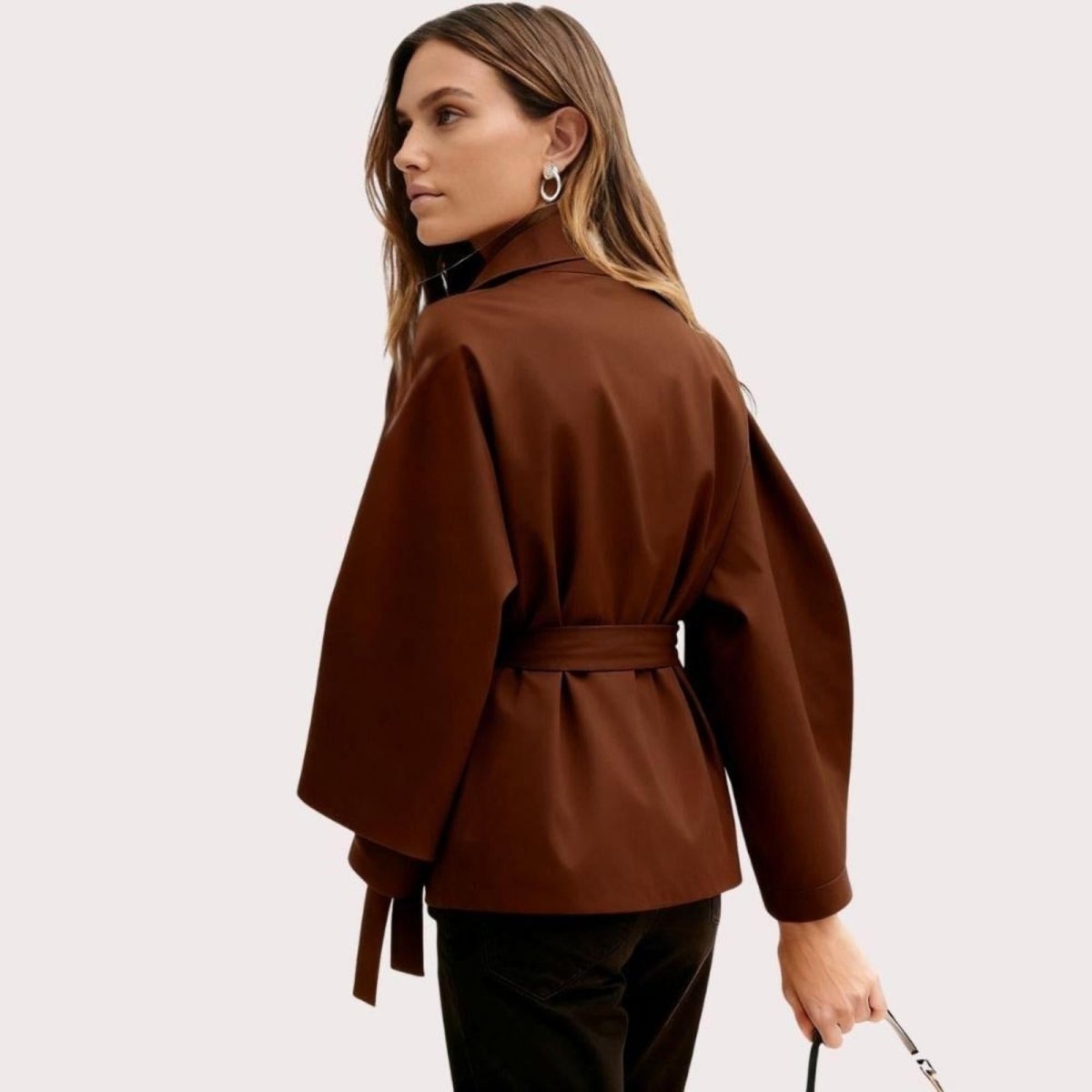 Model wearing Kouvr Fashion belted cape jacket with funnel neck and wide kimono sleeves