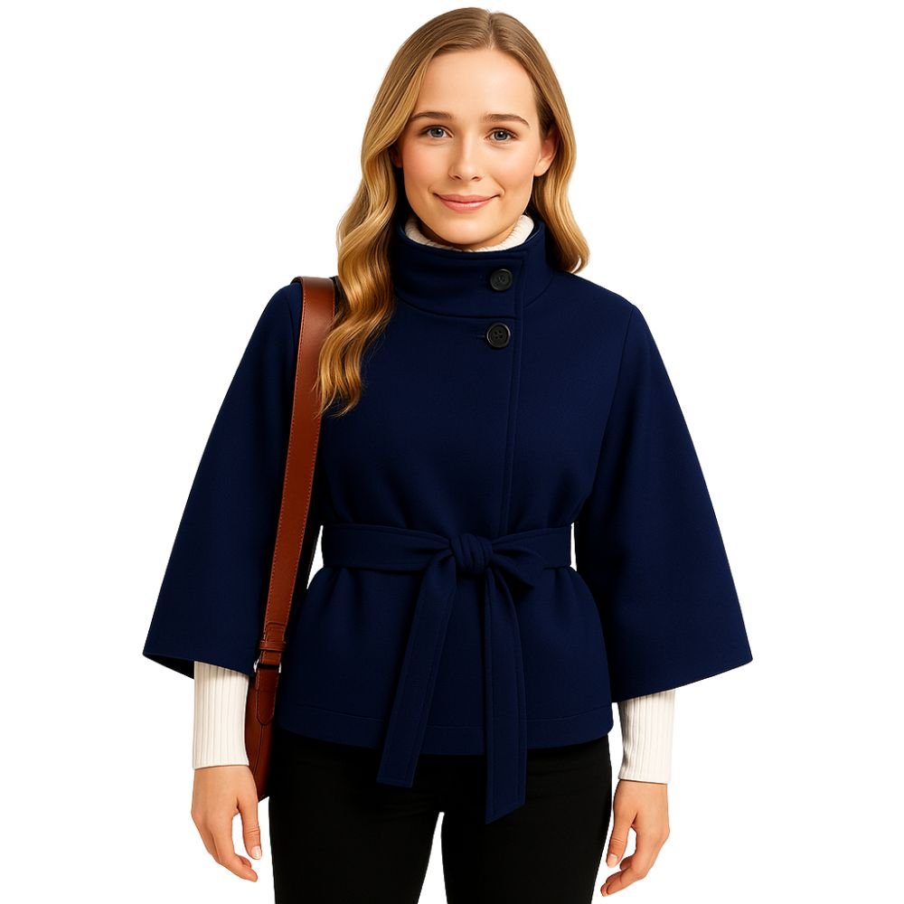 Woman wearing the Kouvr Jaye Cape in navy blue, featuring a high funnel neck, wide sleeves, and a self-tie belt