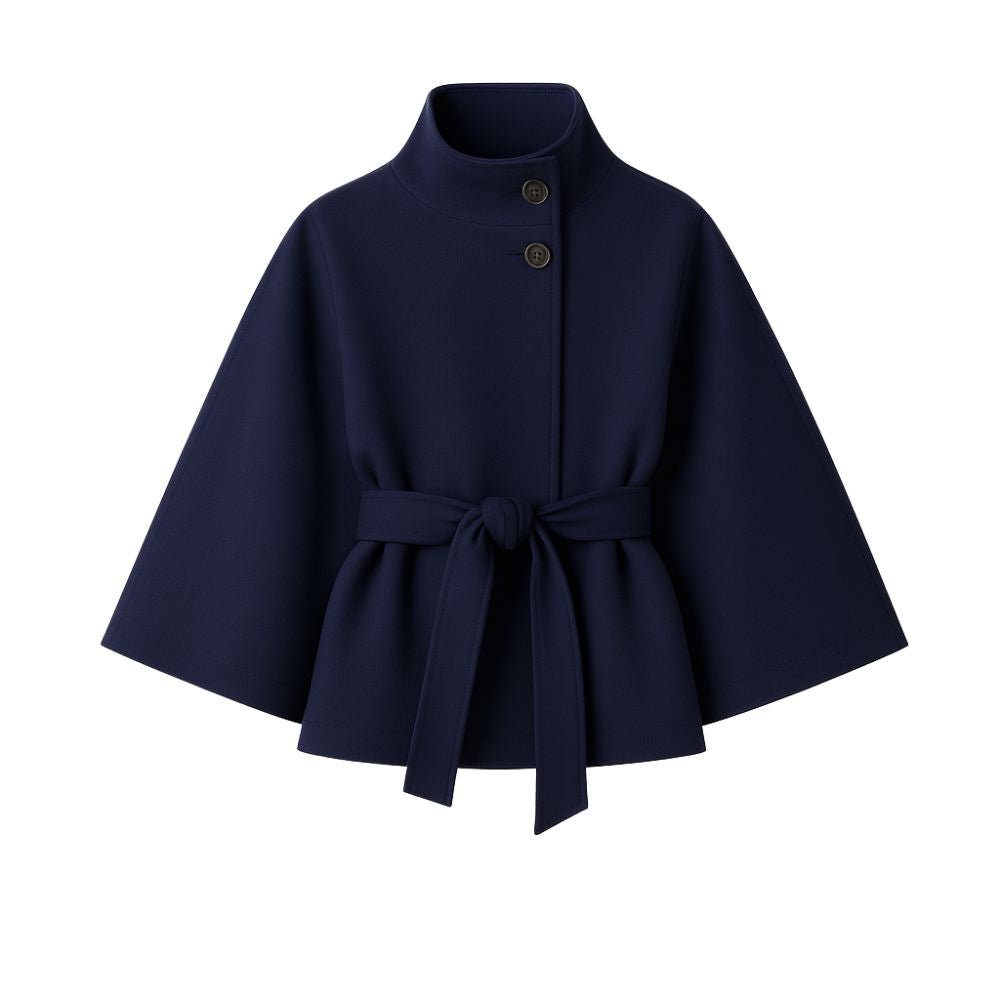 Woman wearing the Kouvr Jaye Cape in navy blue, featuring a high funnel neck, wide sleeves, and a self-tie belt
