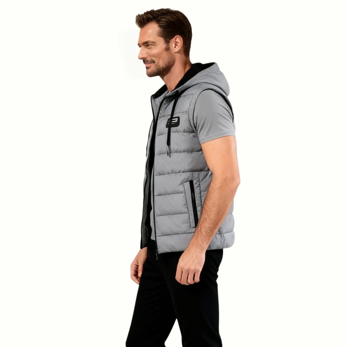 Side profile of a male model in the slate grey Kouvr hooded gilet, showcasing the slim fit and armhole cut for athletic movement. 