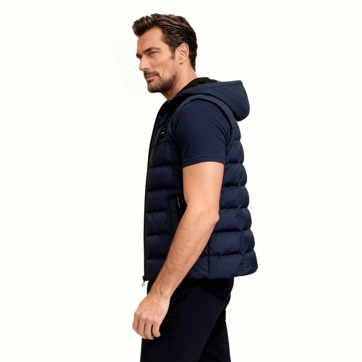 Side profile of a man in a navy blue quilted gilet with a hood, showing its slim silhouette.